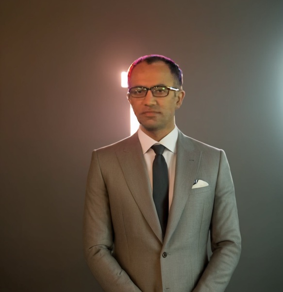 Muhammad Zaheer wearing a grey suit